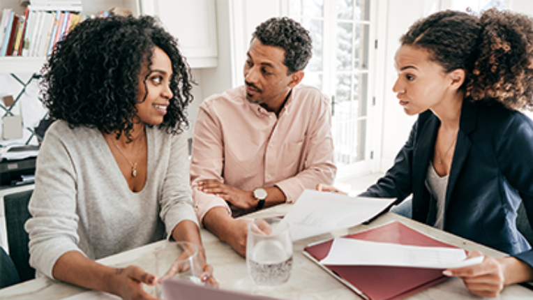 A couple looking at monthly world markets report with their financial advisor